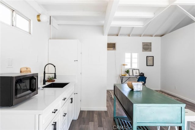 kitchen with beamed ceiling, sink, white cabinets, and dark hardwood / wood-style flooring