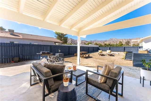 view of patio featuring a mountain view, an outdoor hangout area, central air condition unit, and a grill