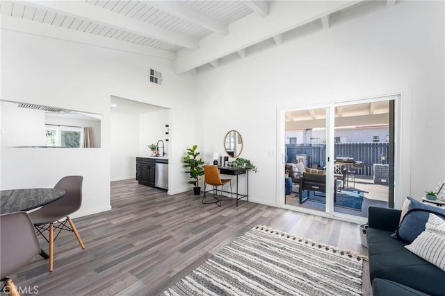 living room featuring hardwood / wood-style flooring, high vaulted ceiling, and beam ceiling