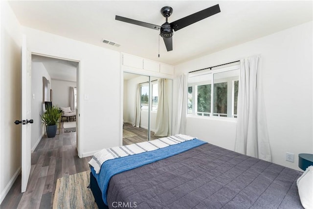 bedroom with dark hardwood / wood-style flooring, a closet, and ceiling fan