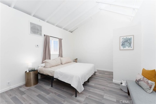 bedroom with lofted ceiling with beams and light wood-type flooring