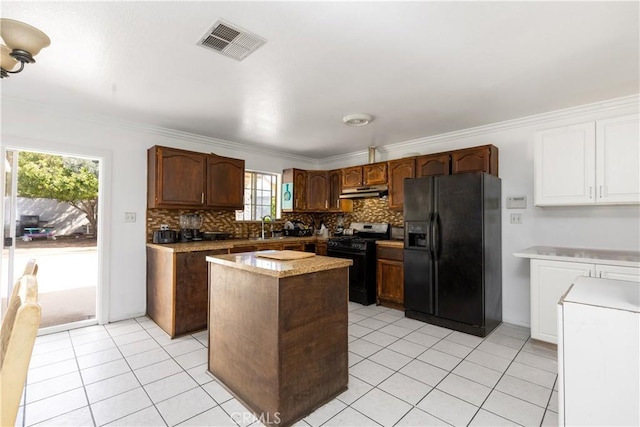 kitchen with visible vents, a center island, under cabinet range hood, light countertops, and black appliances