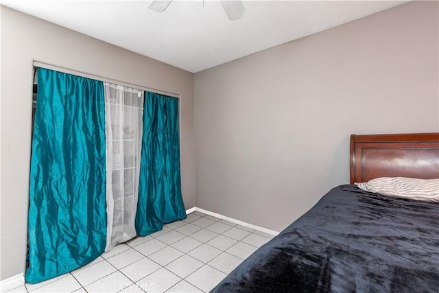 unfurnished bedroom with light tile patterned flooring, ceiling fan, and baseboards