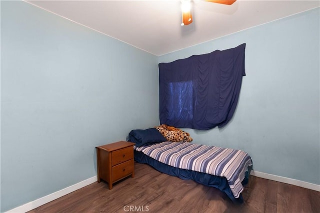 bedroom featuring dark wood-type flooring, a ceiling fan, and baseboards