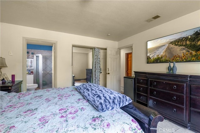 bedroom with ensuite bath, visible vents, and a closet