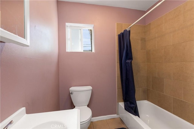 bathroom featuring tile patterned flooring, baseboards, shower / bathtub combination with curtain, and toilet