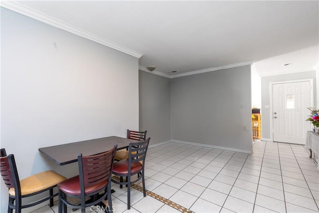 dining space featuring light tile patterned floors, baseboards, and crown molding