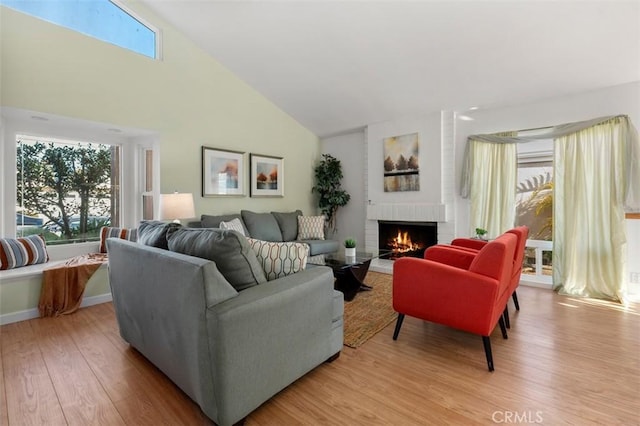 living room with a healthy amount of sunlight, a fireplace, and light hardwood / wood-style flooring