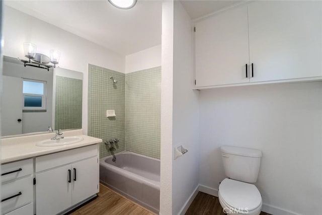 full bathroom featuring wood-type flooring, tiled shower / bath, vanity, and toilet