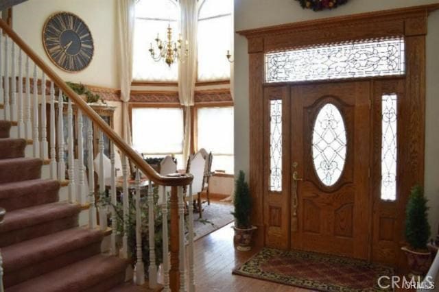 entrance foyer with an inviting chandelier, hardwood / wood-style floors, and plenty of natural light