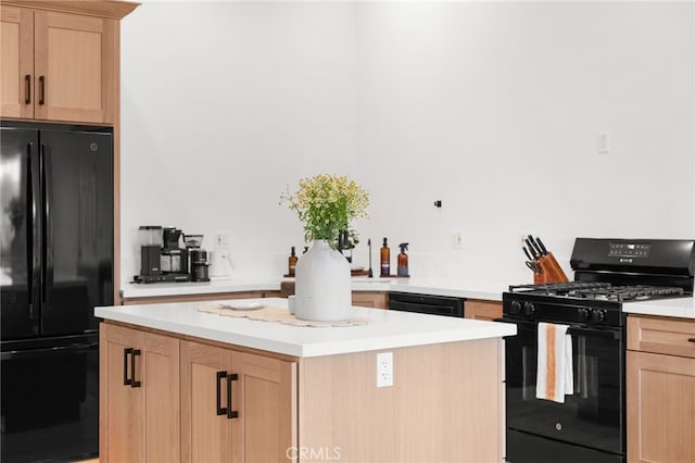 kitchen featuring light brown cabinetry, a center island, and black appliances