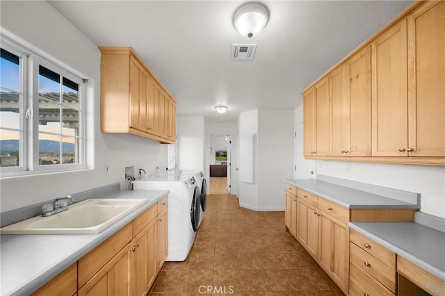 kitchen featuring independent washer and dryer, tile patterned floors, sink, and light brown cabinets