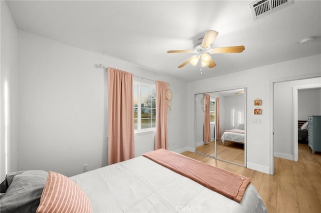 bedroom with light hardwood / wood-style floors, a closet, and ceiling fan