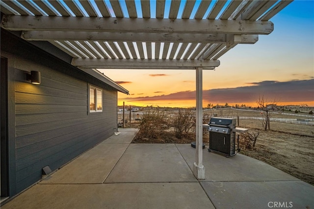 patio terrace at dusk with a grill and a pergola