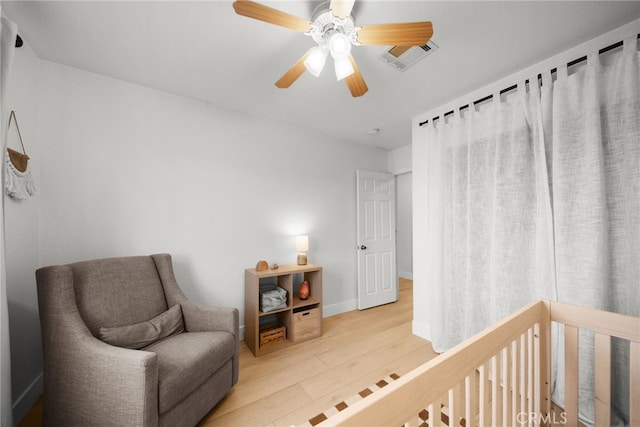 living area with ceiling fan and light hardwood / wood-style floors