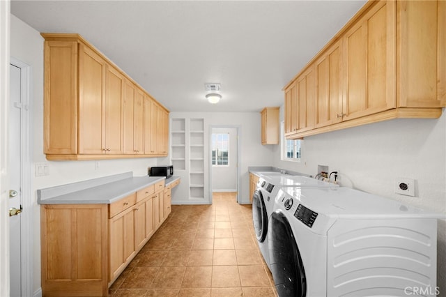 clothes washing area featuring light tile patterned floors, built in features, cabinets, and washing machine and clothes dryer