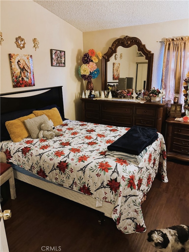 bedroom with hardwood / wood-style flooring, lofted ceiling, and a textured ceiling