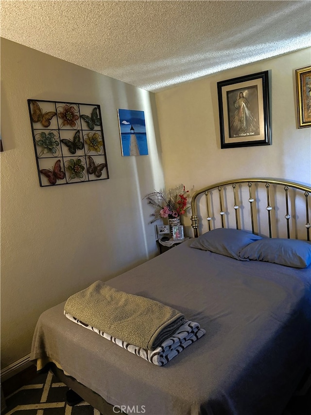 bedroom with vaulted ceiling and a textured ceiling