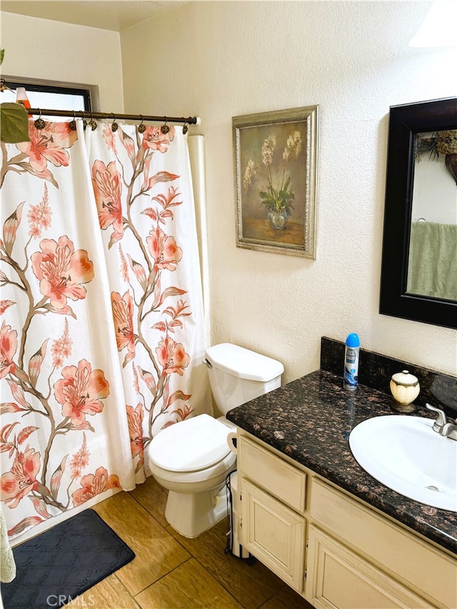 bathroom with vanity, curtained shower, and toilet