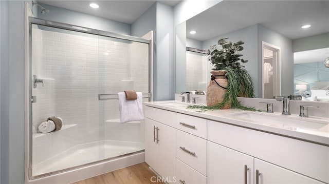 bathroom featuring hardwood / wood-style flooring, vanity, and an enclosed shower