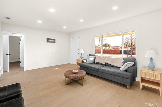 living area with light wood-style flooring, visible vents, baseboards, and recessed lighting