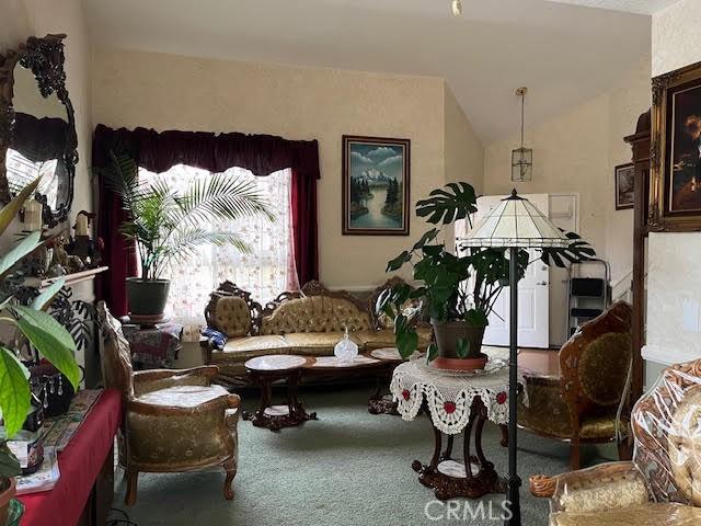 living area with lofted ceiling and carpet floors