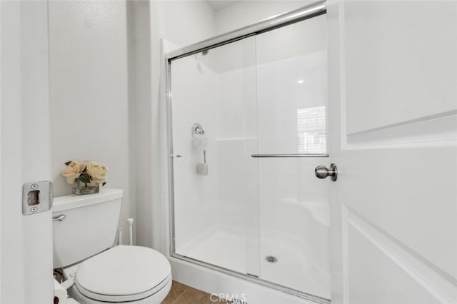 bathroom featuring a shower stall and toilet