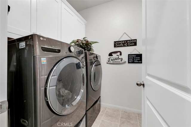 laundry area featuring baseboards, cabinet space, washing machine and clothes dryer, and light tile patterned flooring