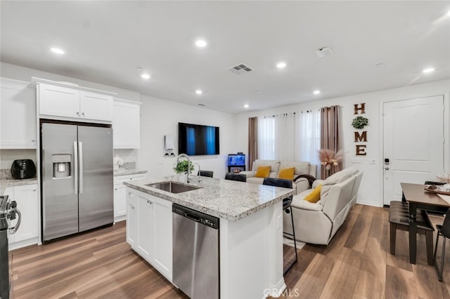 kitchen featuring white cabinetry, stainless steel appliances, sink, and light stone counters