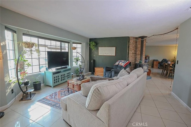 living room with light tile patterned flooring and a wood stove