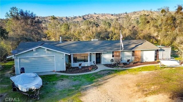 single story home featuring a garage and a front lawn