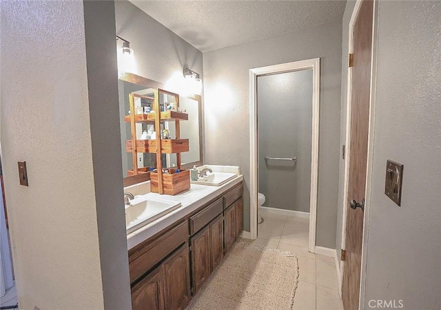 bathroom featuring tile patterned flooring, vanity, a textured ceiling, and toilet