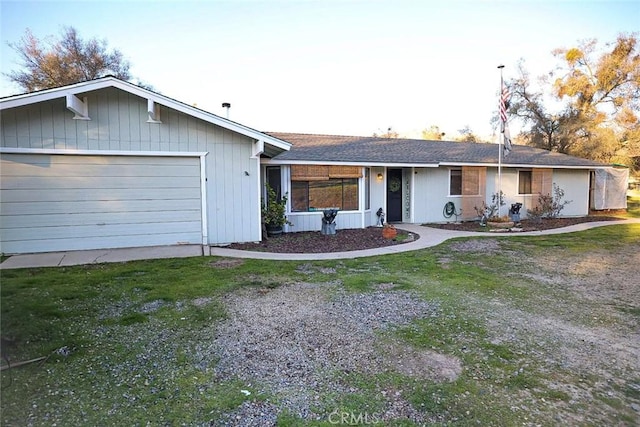 ranch-style house with a garage and a front lawn