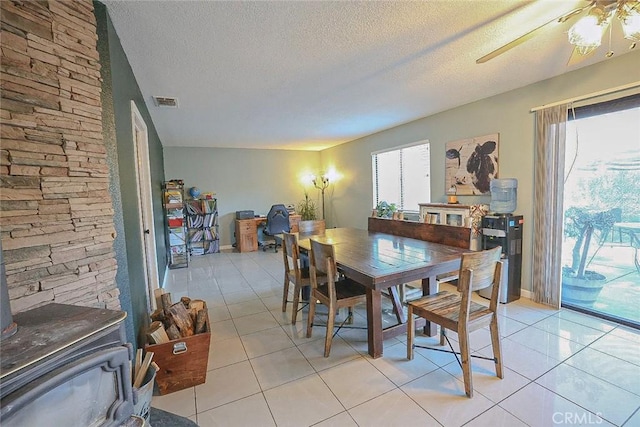 dining area featuring light tile patterned floors, a textured ceiling, and ceiling fan