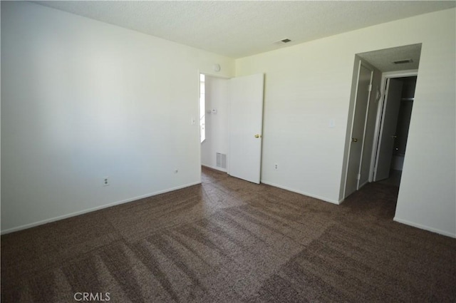 empty room featuring dark colored carpet