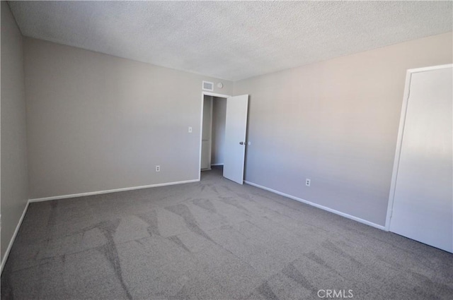 unfurnished room with carpet flooring and a textured ceiling