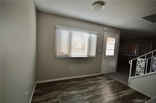 entryway featuring a textured ceiling and dark hardwood / wood-style flooring