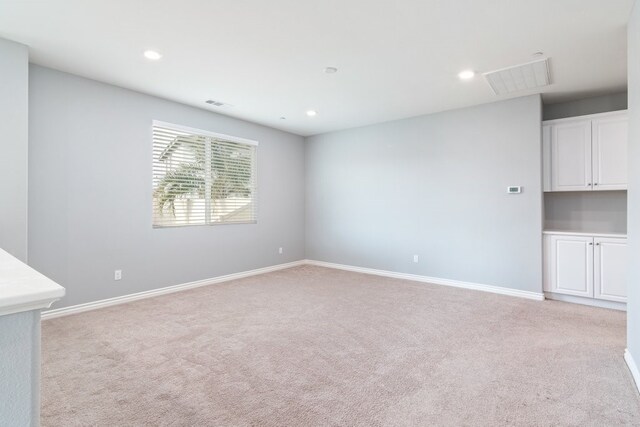 unfurnished room featuring light colored carpet