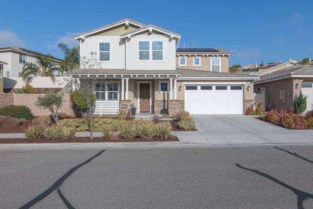 view of front of property with a garage and solar panels