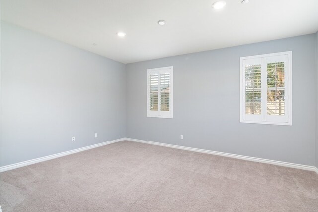 spare room with a healthy amount of sunlight and light colored carpet