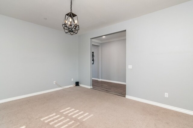 empty room with a notable chandelier and carpet