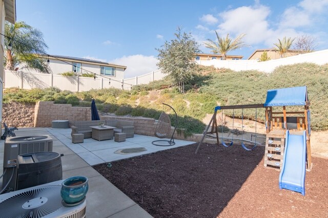 view of yard featuring a playground, cooling unit, and a patio area