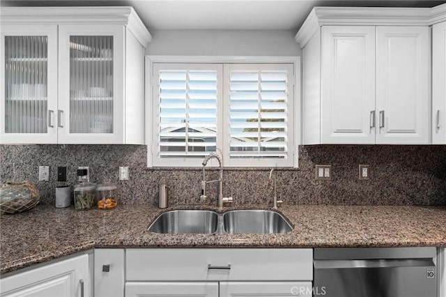 kitchen with sink, white cabinetry, dishwasher, dark stone counters, and decorative backsplash