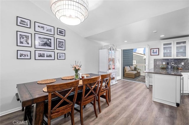 dining space featuring vaulted ceiling and light hardwood / wood-style flooring