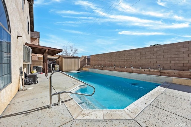 view of swimming pool with a patio, central AC, and a storage shed