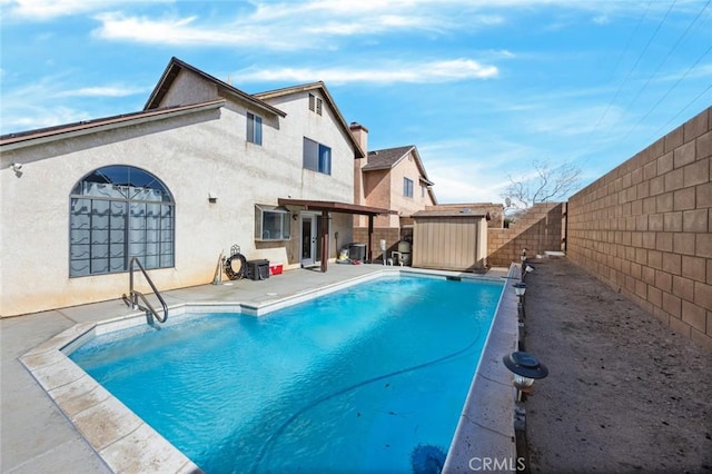 view of swimming pool with a storage shed and a patio