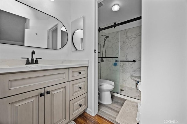 bathroom with walk in shower, vanity, toilet, and hardwood / wood-style floors