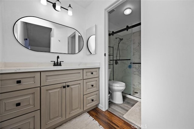 bathroom with vanity, hardwood / wood-style flooring, toilet, and walk in shower