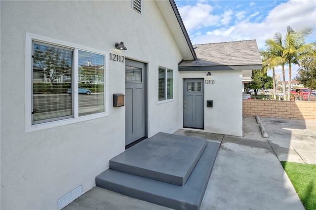 view of exterior entry with a patio