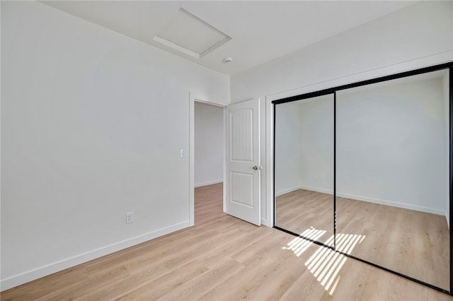 unfurnished bedroom featuring a closet and light hardwood / wood-style flooring